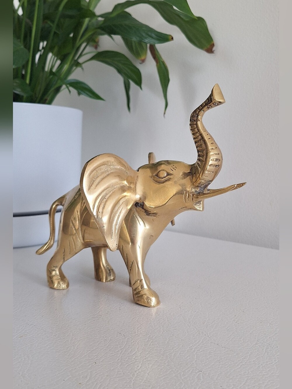 Brass elephant with its trunk raised